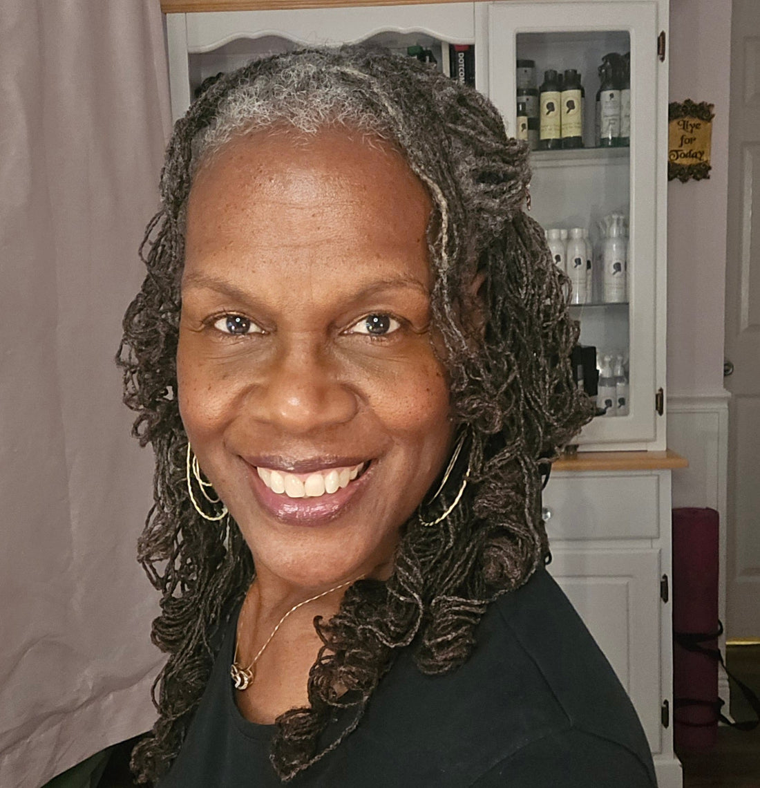 Confident Black woman embracing her gray Sisterlocks through self-love and community